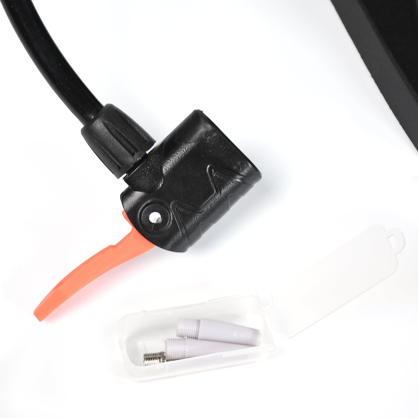 Close-up of a compact foot pump for bikes with nozzle attachment and storage case for additional tips