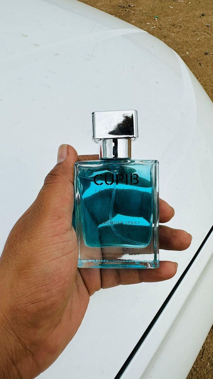 Hand holding blue glass bottle of Perfume for Men 50 ML Pack of 2 with silver cap on white surface