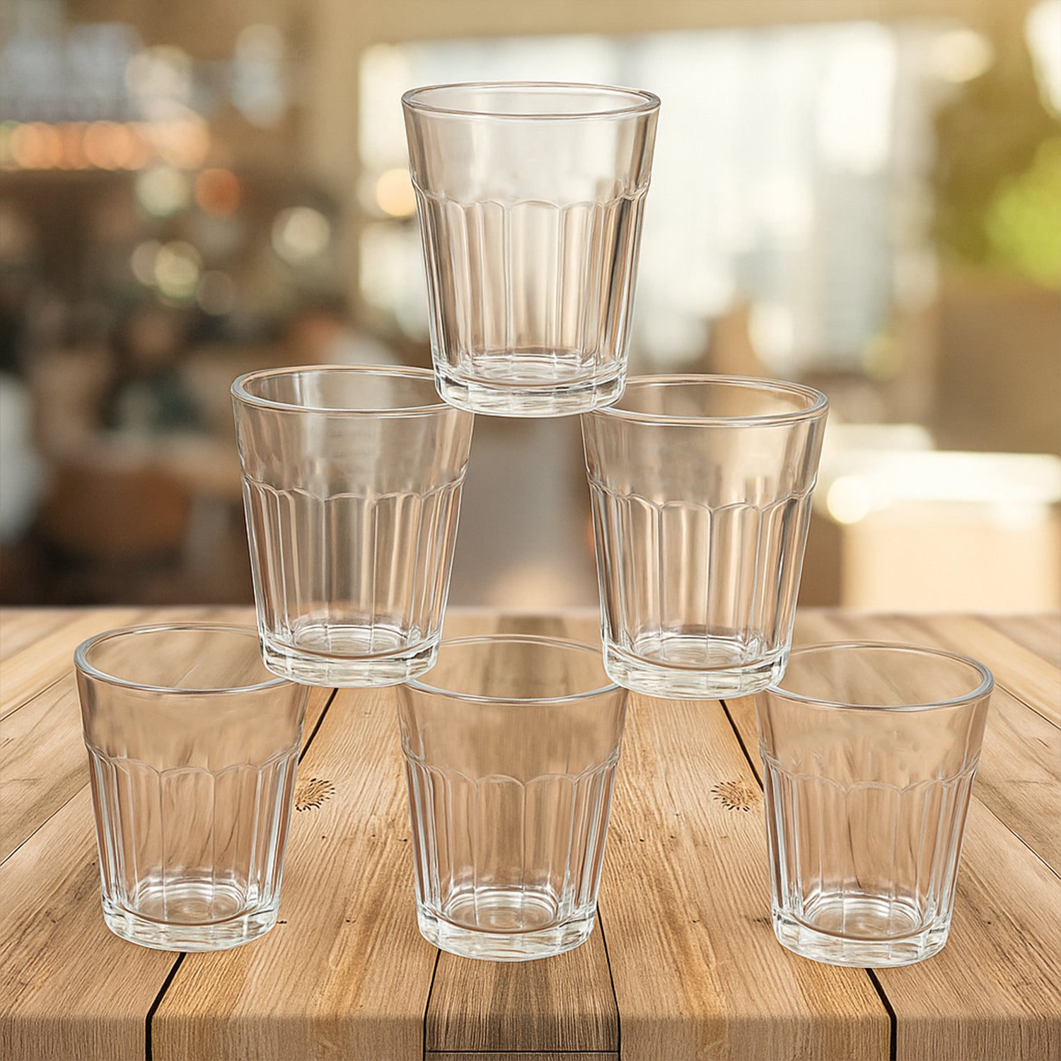 Set of five transparent glasses stacked on a wooden table, ideal for serving cutting chai glass set
