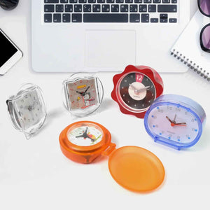 Colorful decorative clocks for every room displayed on a desk with a laptop and accessories
