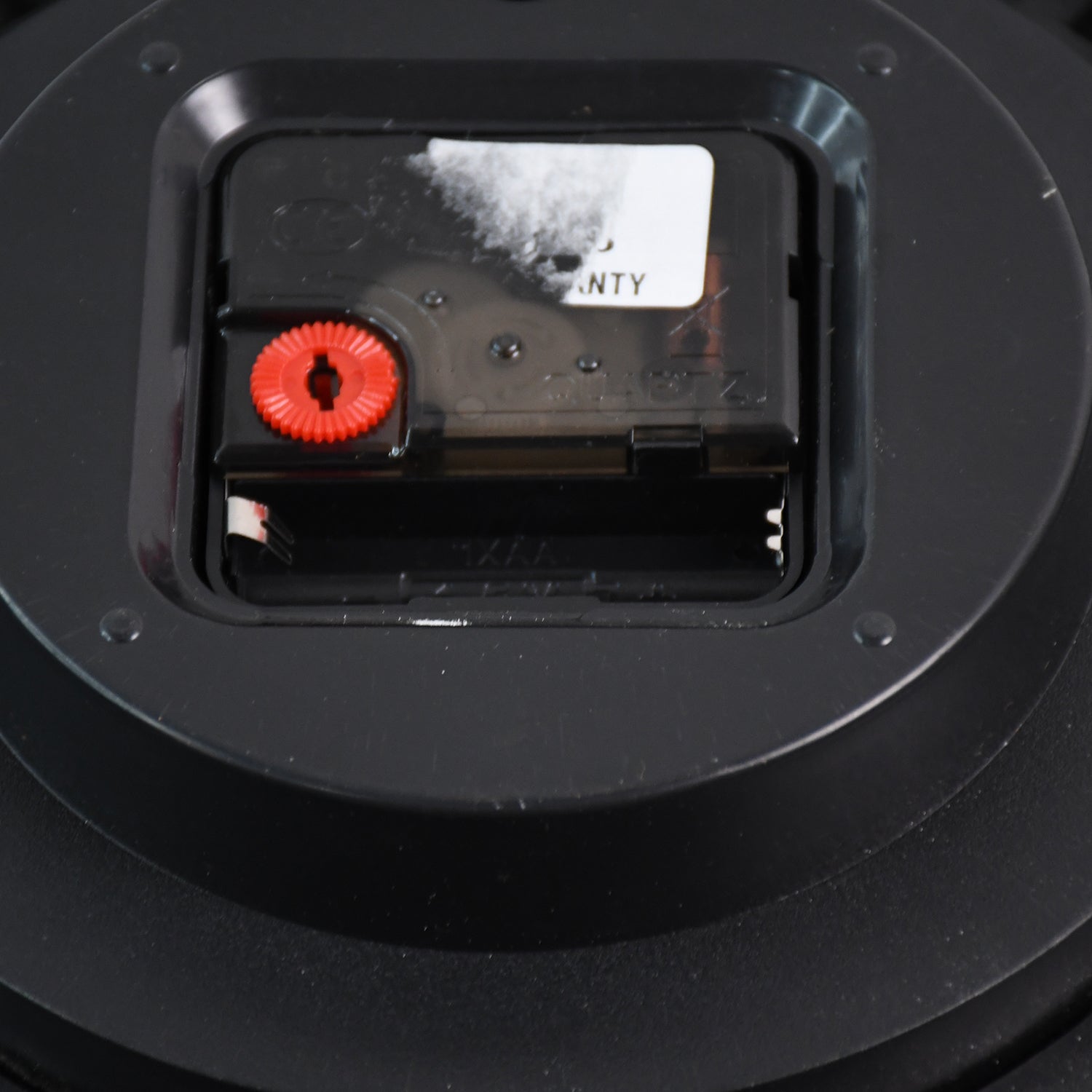 Back view of a decorative wall clock showing the battery compartment and clock mechanism