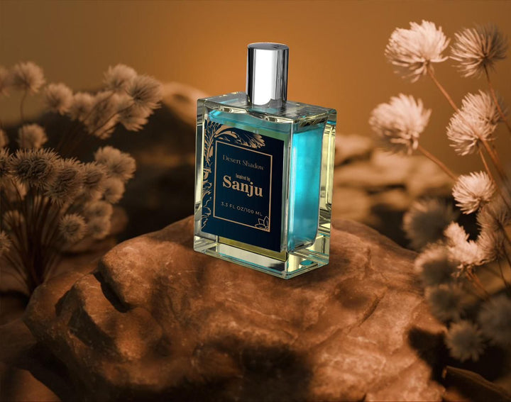 Superior eMart perfume bottle with blue liquid inspired by Sanju perfume placed on a rock with blurred dried flowers background