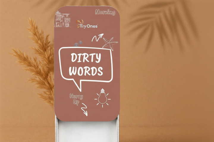 Try Ones 'Dirty Words' brown card game box featuring white graphics, set against a tan background with pampas grass.