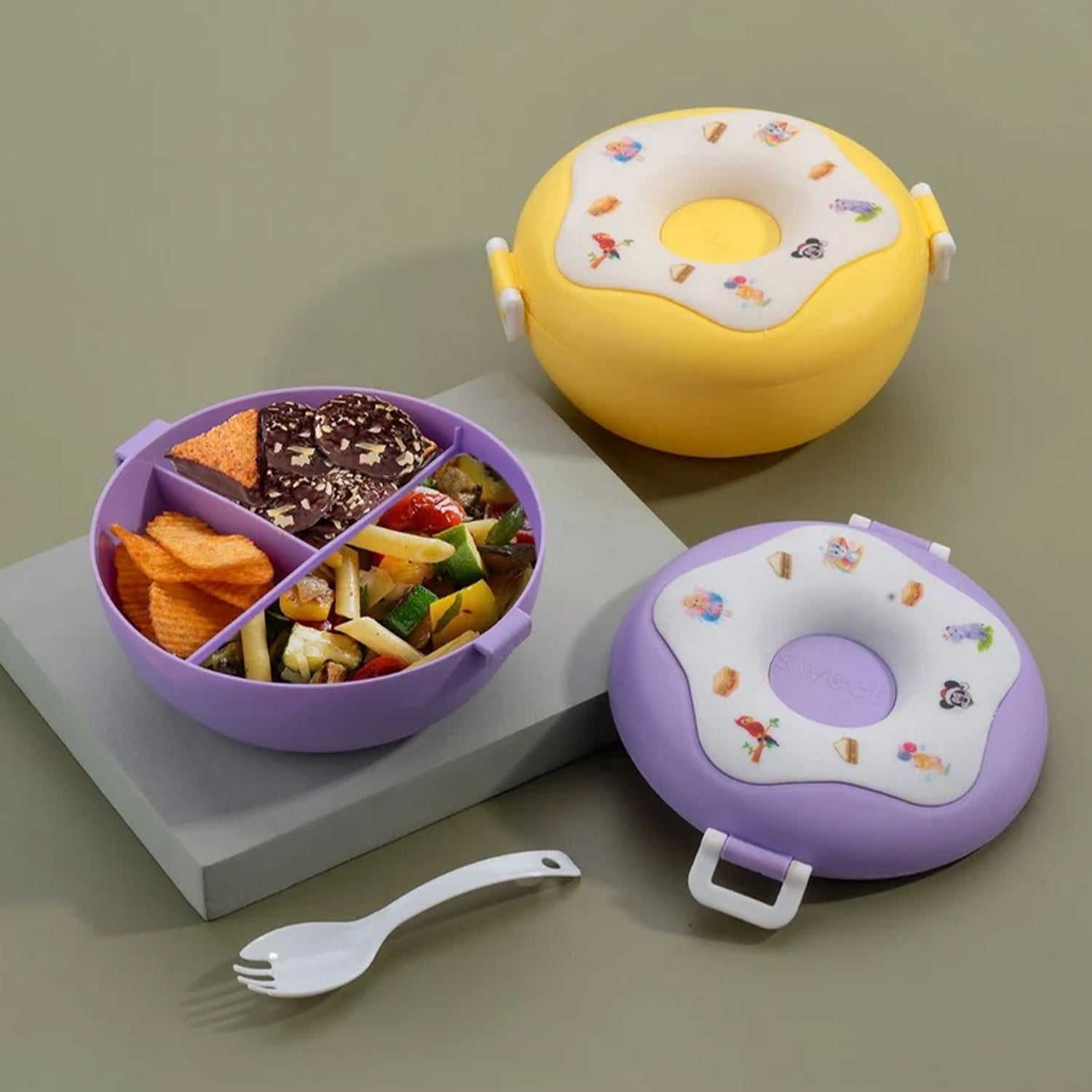 Fun donut shaped lunch box in yellow and purple for kids, featuring multiple compartments for meals