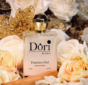 Dori By S N Feminine Oud Unisex Perfume 100ml Bottle Surrounded by White Roses and Gold Accents