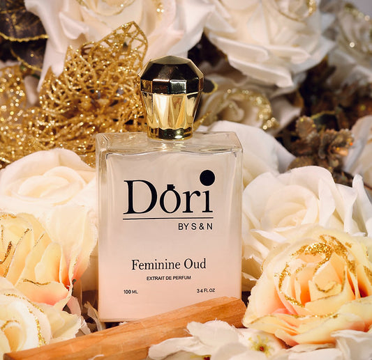 Dori By S N Feminine Oud Unisex Perfume 100ml Bottle Surrounded by White Roses and Gold Accents
