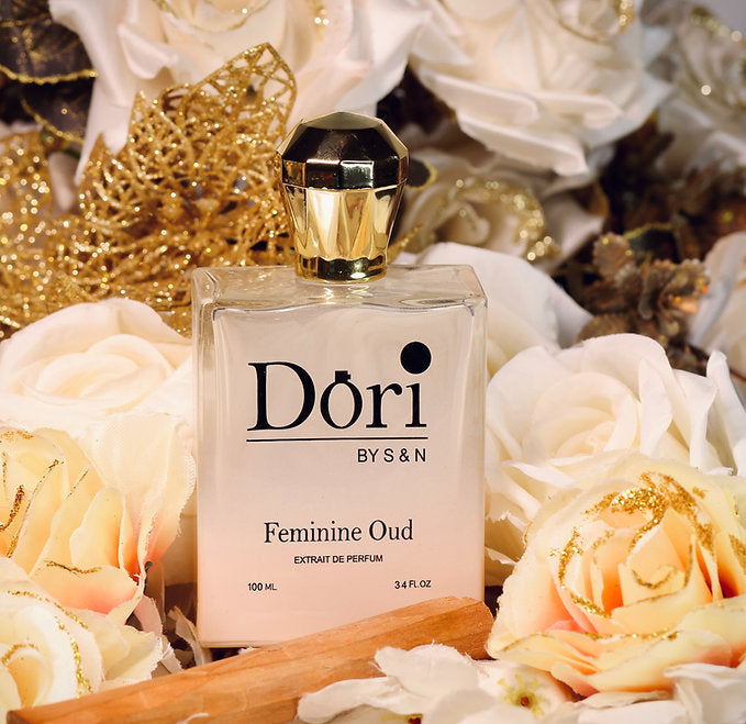 Dori By S N Feminine Oud Unisex Perfume 100ml Bottle Surrounded by White Roses and Gold Accents