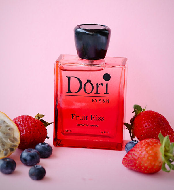 Fruit Kiss Women Perfume by Dori in a glass bottle surrounded by fresh berries on a pink background