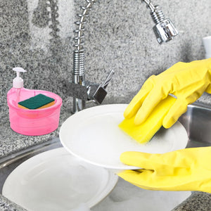 Double layer soap dispenser with sponge in pink next to kitchen sink with hands washing plate using yellow gloves