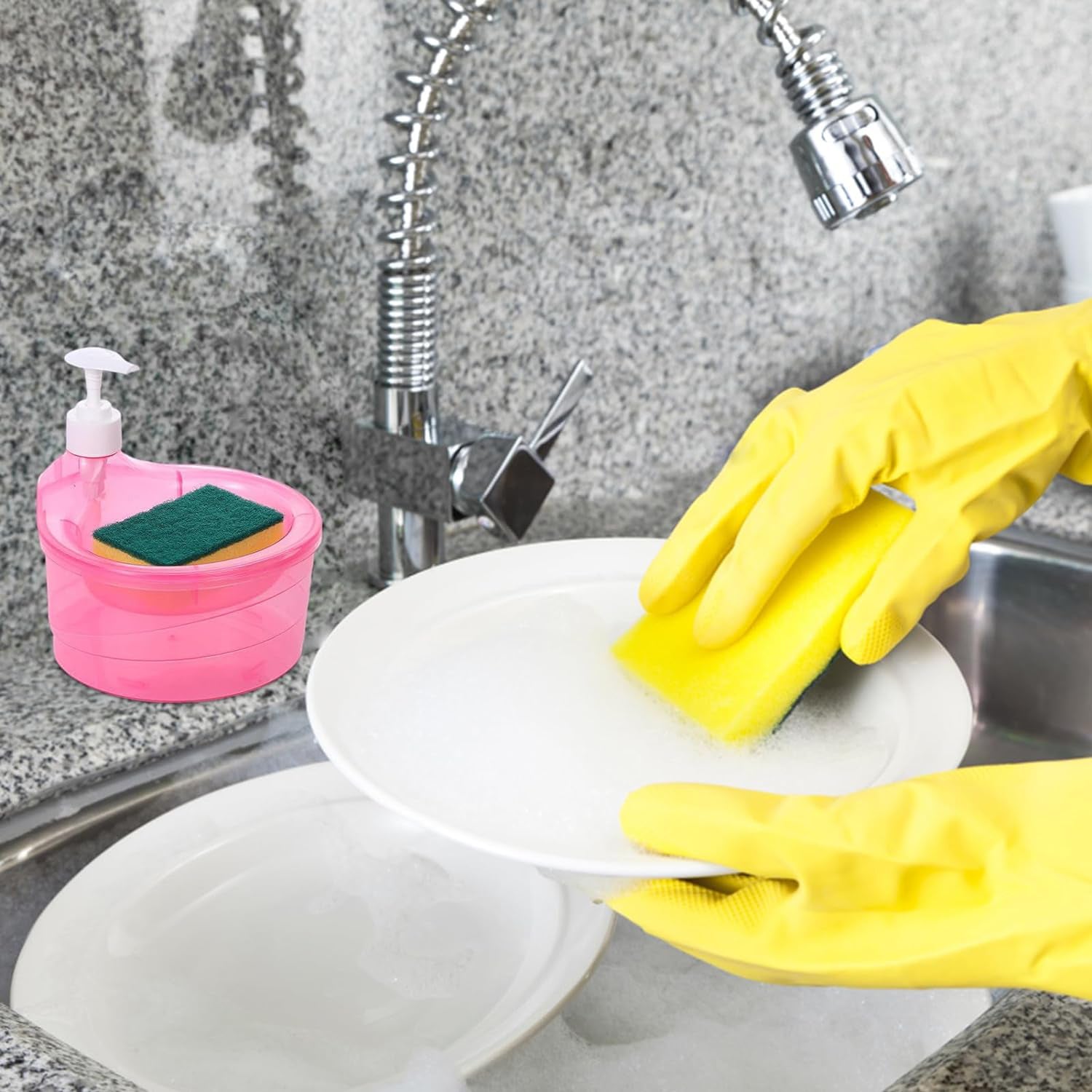 Double layer soap dispenser with sponge in pink next to kitchen sink with hands washing plate using yellow gloves
