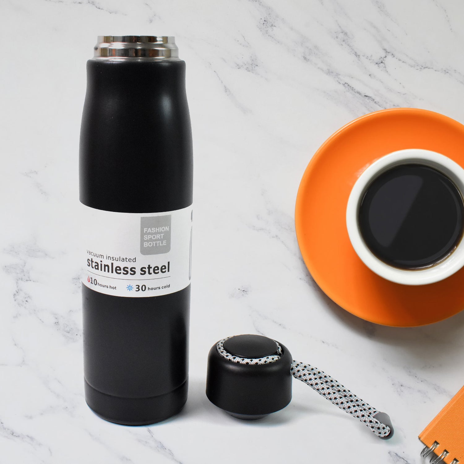 Black double wall vacuum insulated water bottle with stainless steel design and cap on a kitchen countertop