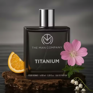 Perfume bottle labeled 'Titanium' by The Man Company with a flower and orange slice on a dark background