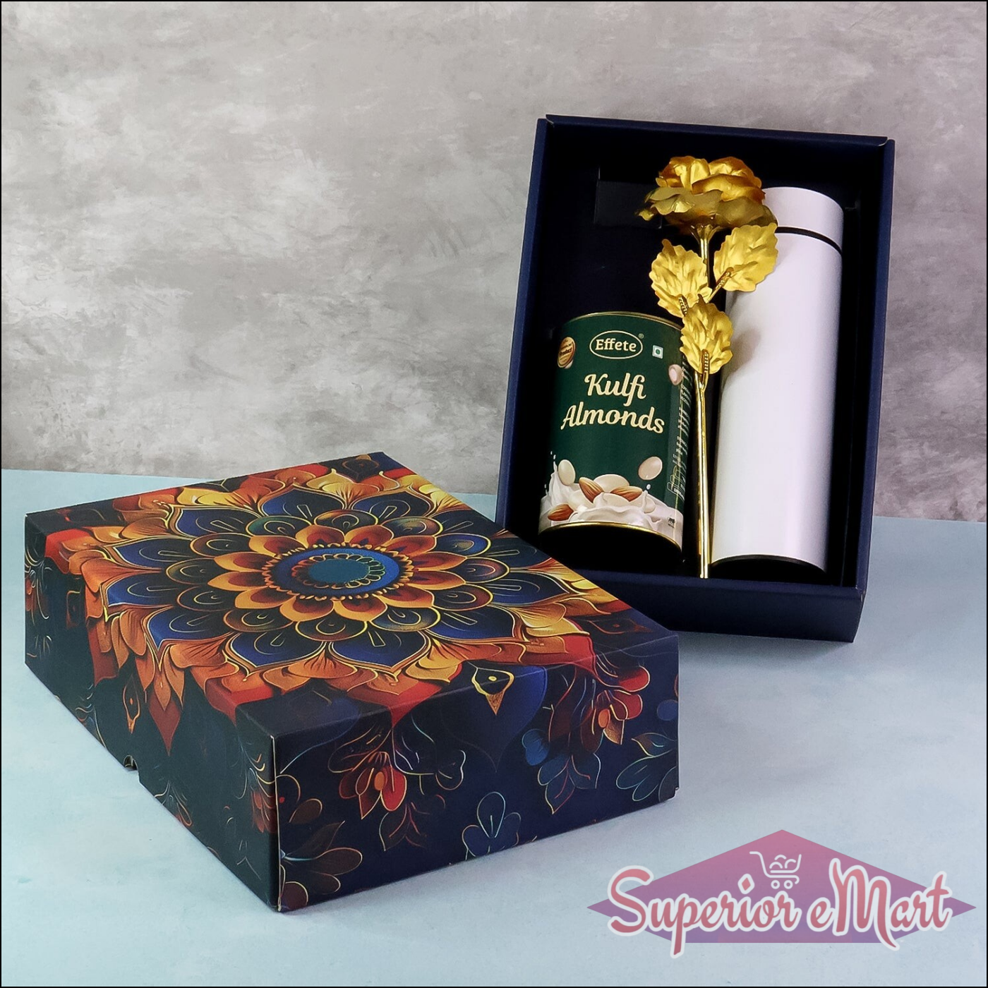 Festive gift hamper box decorated with floral design, featuring kulfi almonds and a decorative item