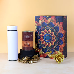 Festive gift hamper box with coffee blend, stylish canister, and decorative gold flower