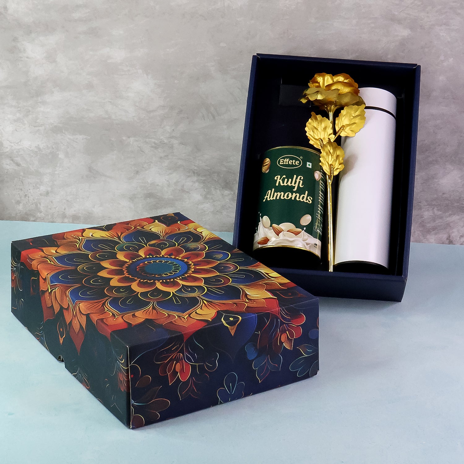 Festive gift hamper box decorated with floral design, featuring kulfi almonds and a decorative item