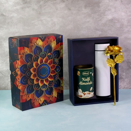 Festive gift hamper box featuring decorative design, kulfi almonds, and a gold flower in a sleek container