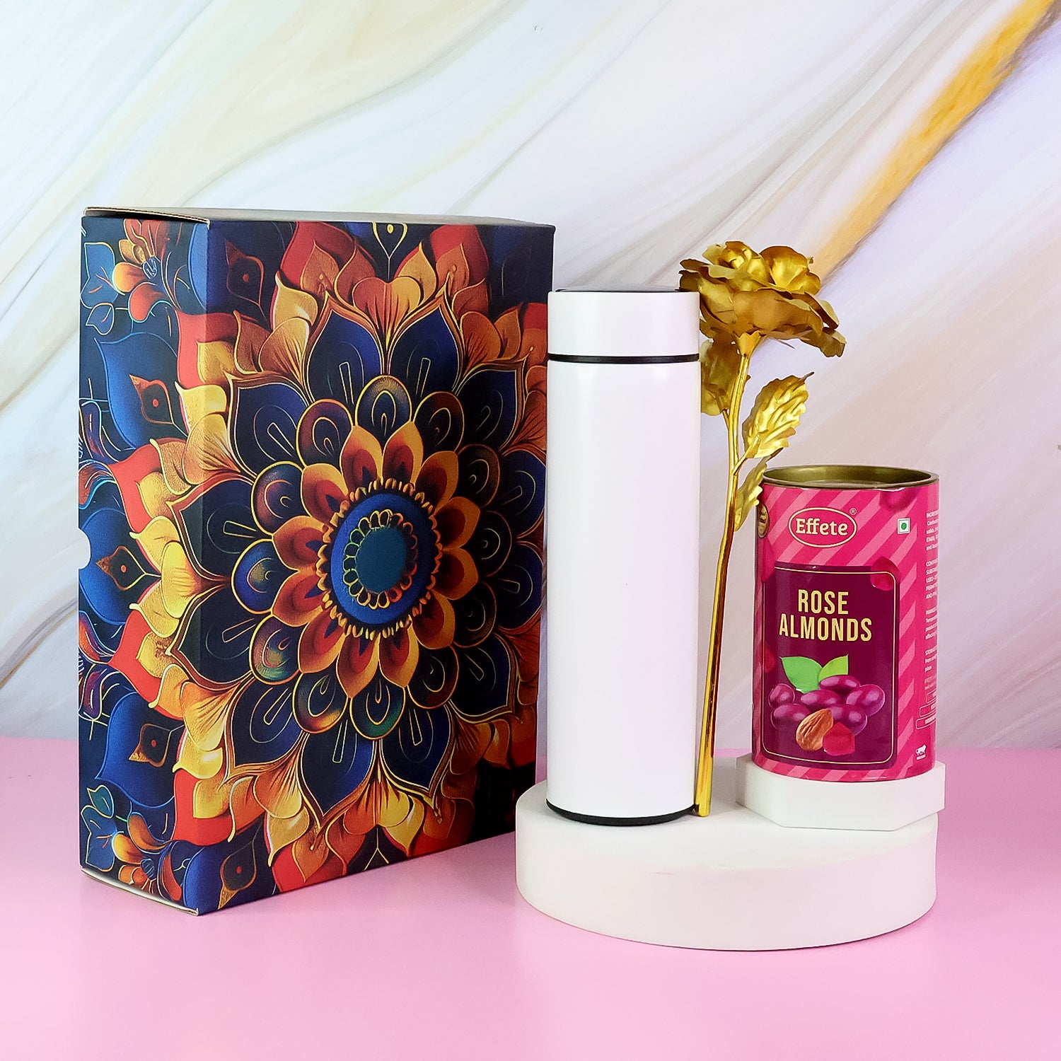 Festive gift hamper with stainless steel bottle, decorative flower, and rose almonds in an elegant box