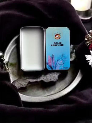 Floral solid perfume for unisex in a sleek metal tin on a decorative tray