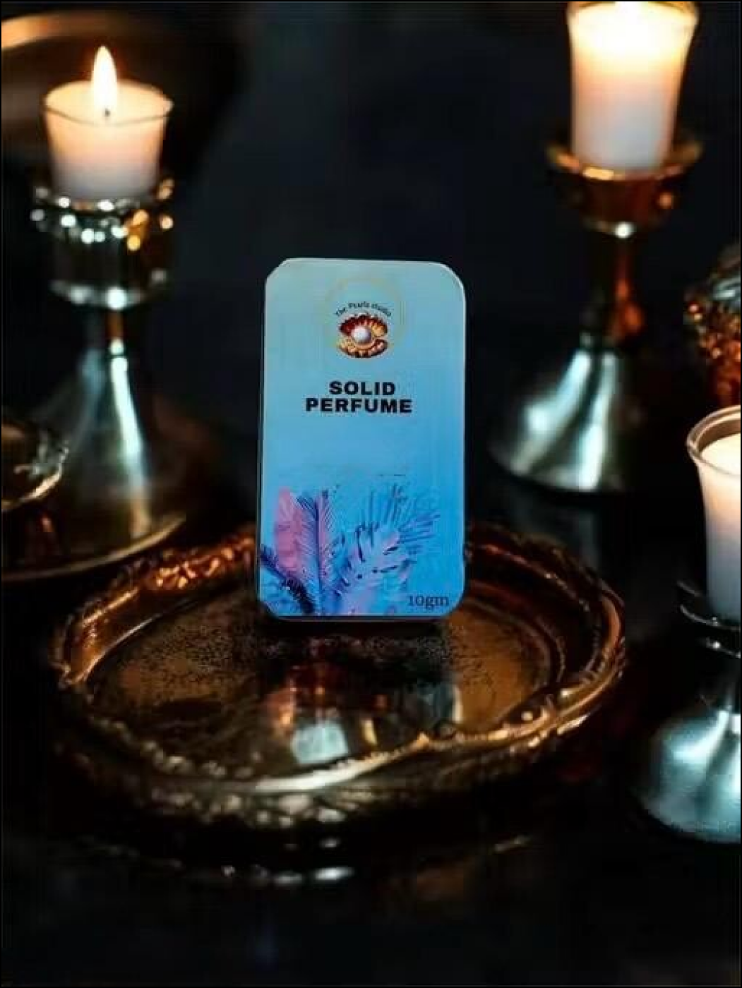 Floral solid perfume for unisex in decorative packaging on metallic tray with candles