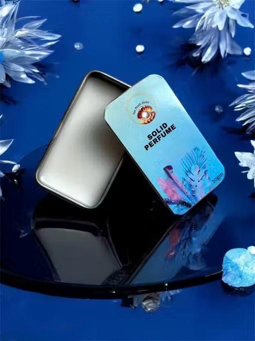 Floral solid perfume for unisex in a compact tin with an elegant design and reflective background