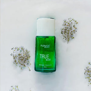 True Musk perfume 30ml in a green glass bottle surrounded by delicate flowers