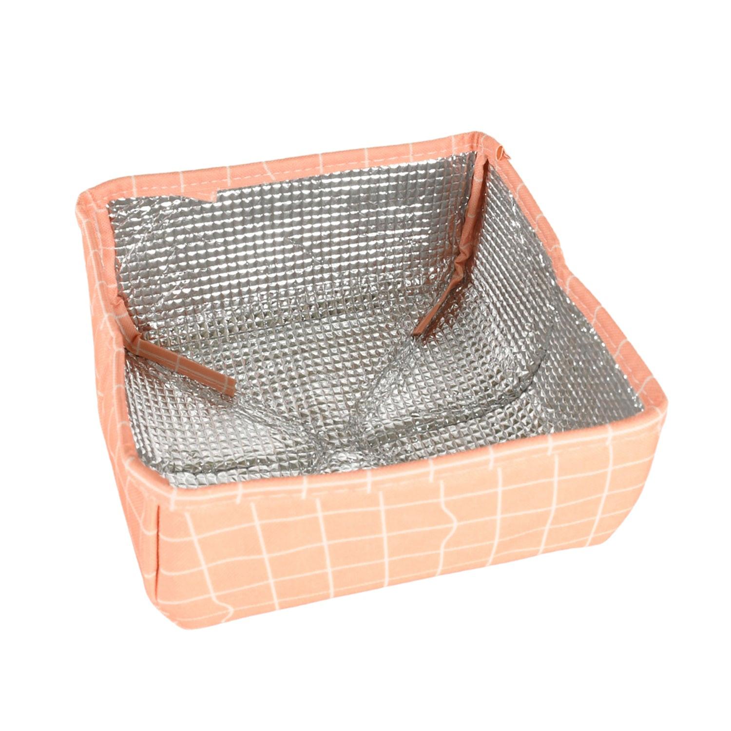 Foldable food cover in peach color with a silver insulated interior for protecting food