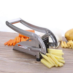 Stainless steel french fry cutter machine with sliced potatoes and carrots on a wooden surface
