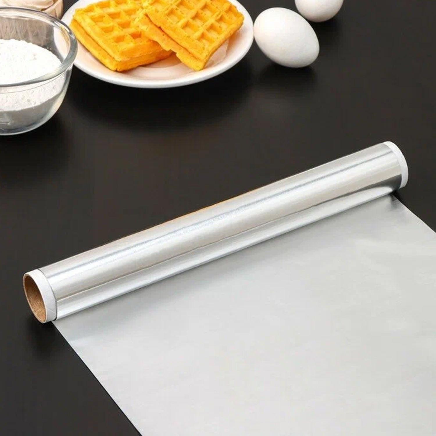 Heavy duty aluminum foil roll on a kitchen counter with cooking ingredients and waffles