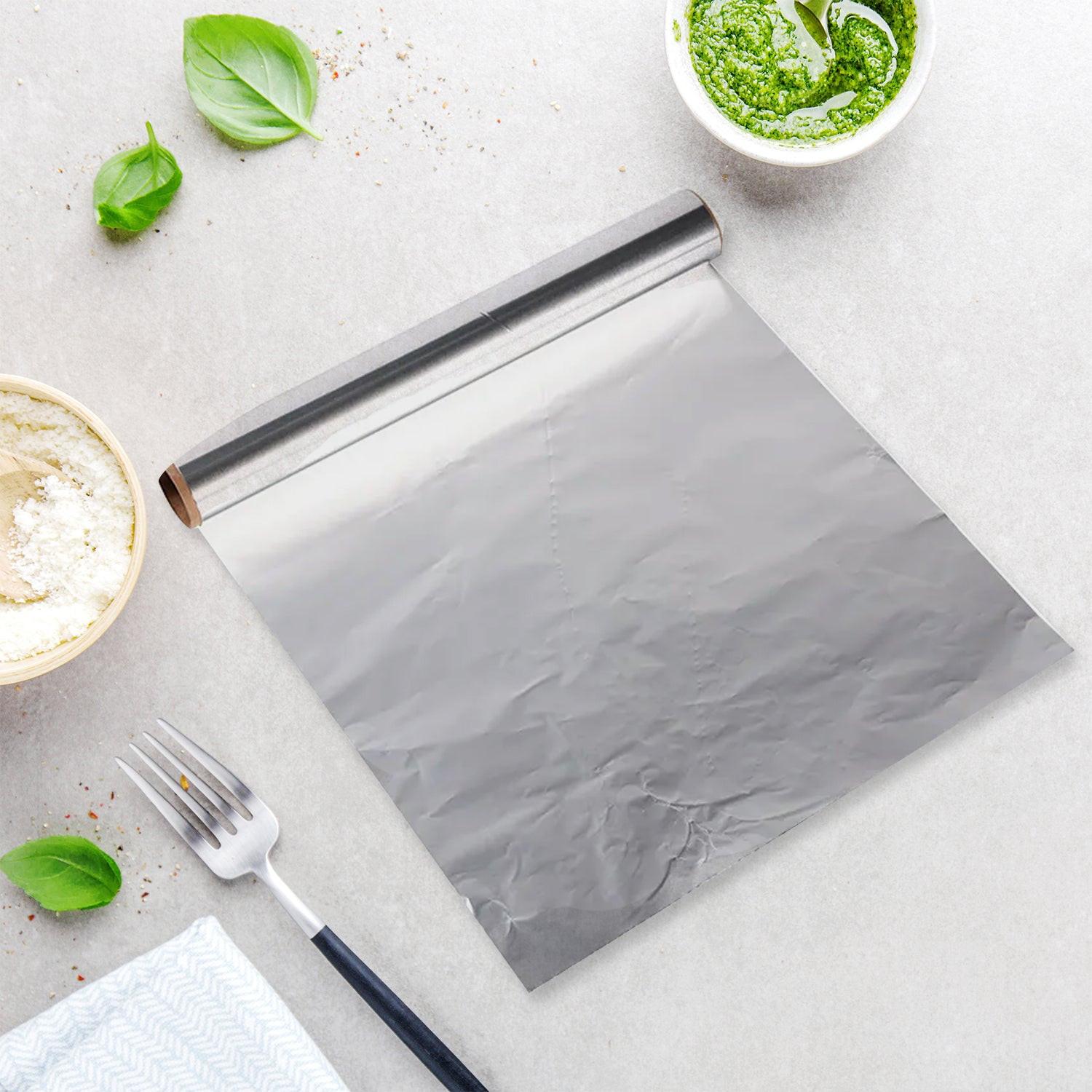 Heavy duty aluminum foil roll laid out on a kitchen countertop with fresh ingredients