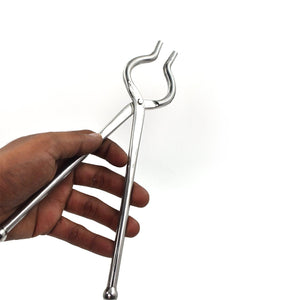 Hand holding stainless steel utensil holder tongs for kitchen and cooking tasks