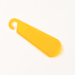 Yellow garlic and ginger grater tool with a textured surface for efficient grating