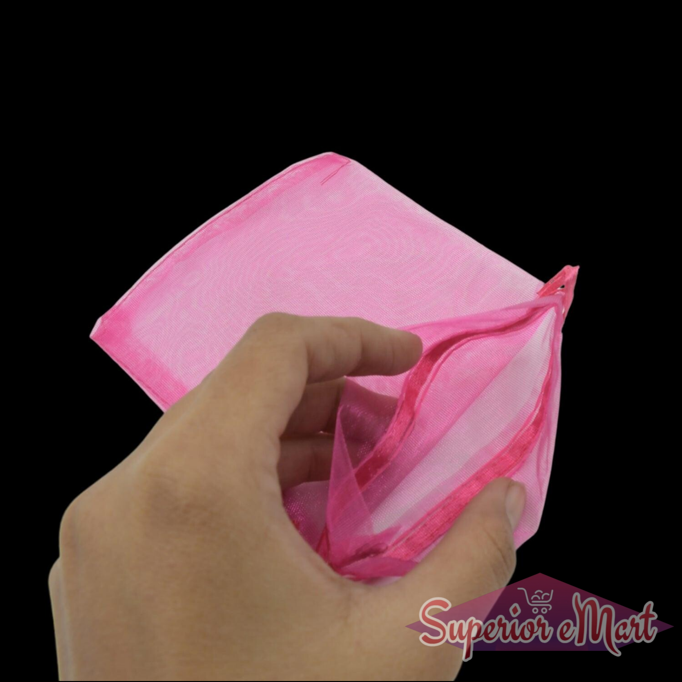 Hand holding a pink small organza gift bag with drawstring for elegant gift wrapping