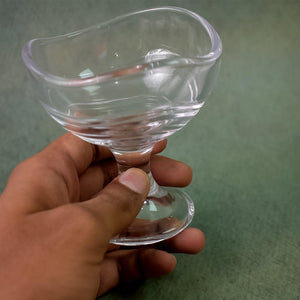 Hand holding a clear glass footed dessert bowl set for serving elegant desserts