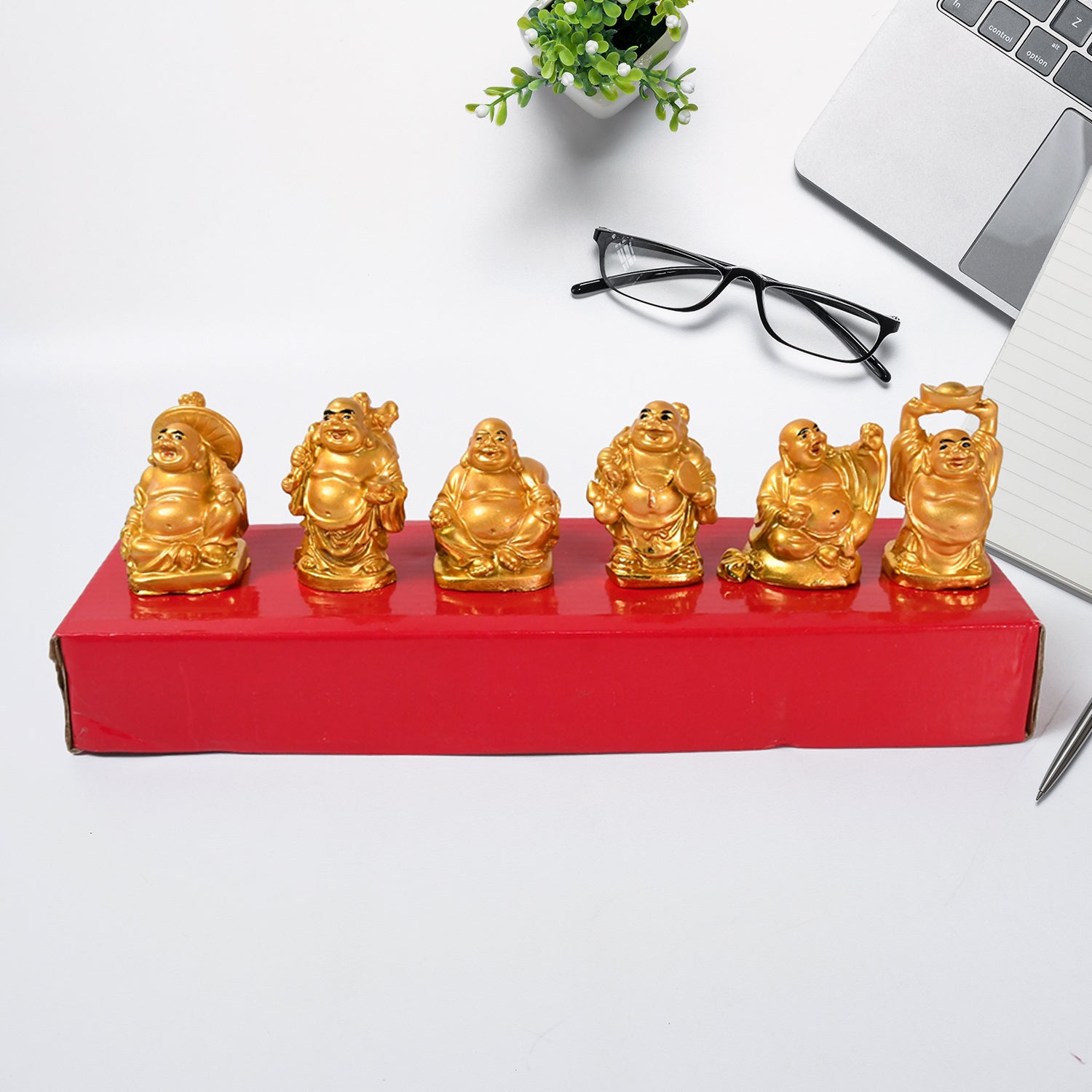 Decorative Golden Laughing Buddha statues set on a red display for home decor enthusiasts