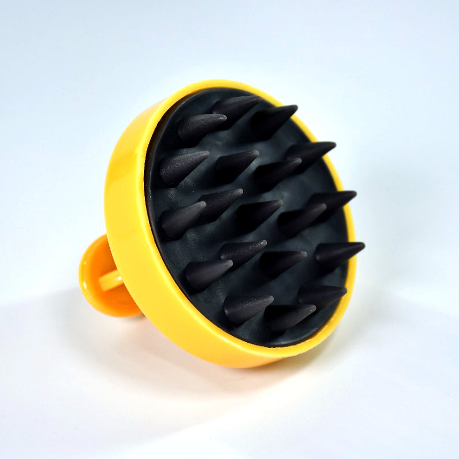 Handheld scalp massager in yellow with soft rubber spikes for soothing baby care and relaxation
