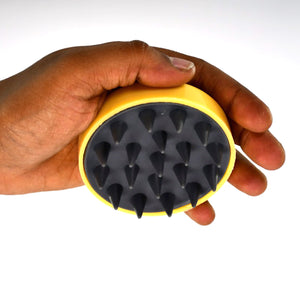 Handheld scalp massager in a hand, designed for soothing relaxation and promoting scalp health