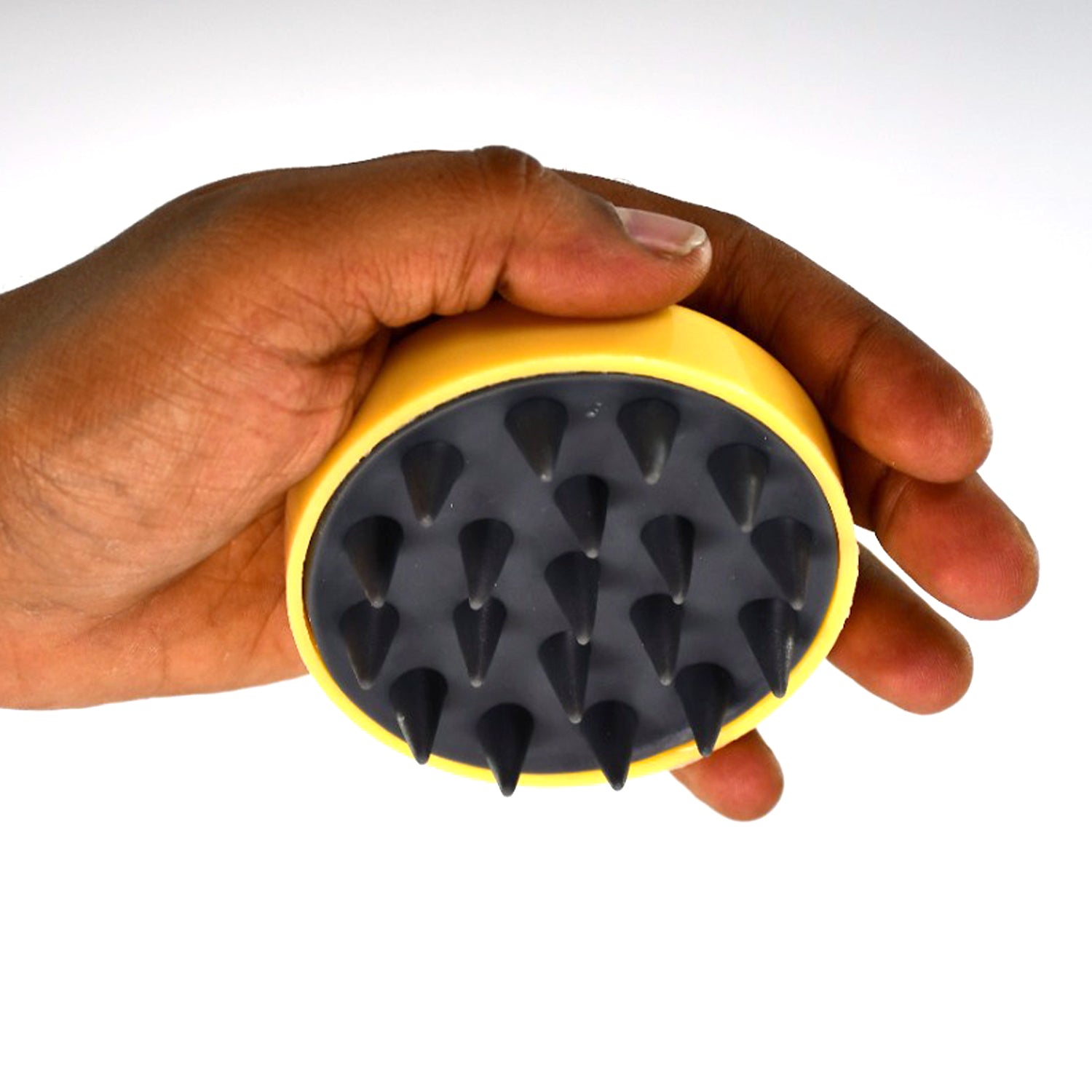 Handheld scalp massager in a hand, designed for soothing relaxation and promoting scalp health