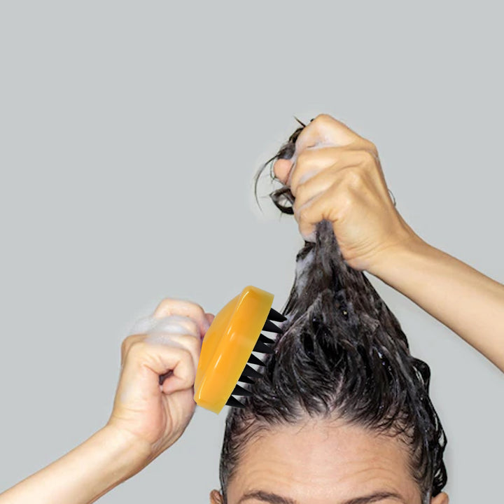 Handheld scalp massager used during a relaxing hair wash for effective scalp stimulation