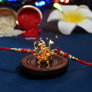 Hanumaan Ji Holding Dronagiri Mountain Rakhi with red thread and gold bead accents on wooden holder