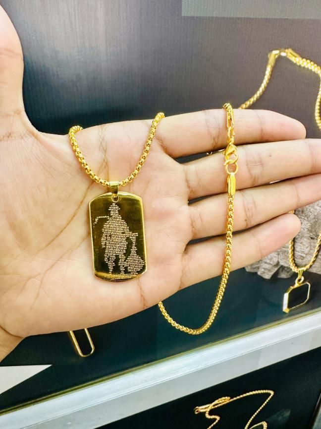 Gold Hanuman Chalisha pendant on a chain held in a hand for spiritual jewelry enthusiasts