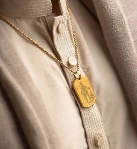 Hanuman Chalisha pendant in gold on a chain, showcased on a light-colored shirt