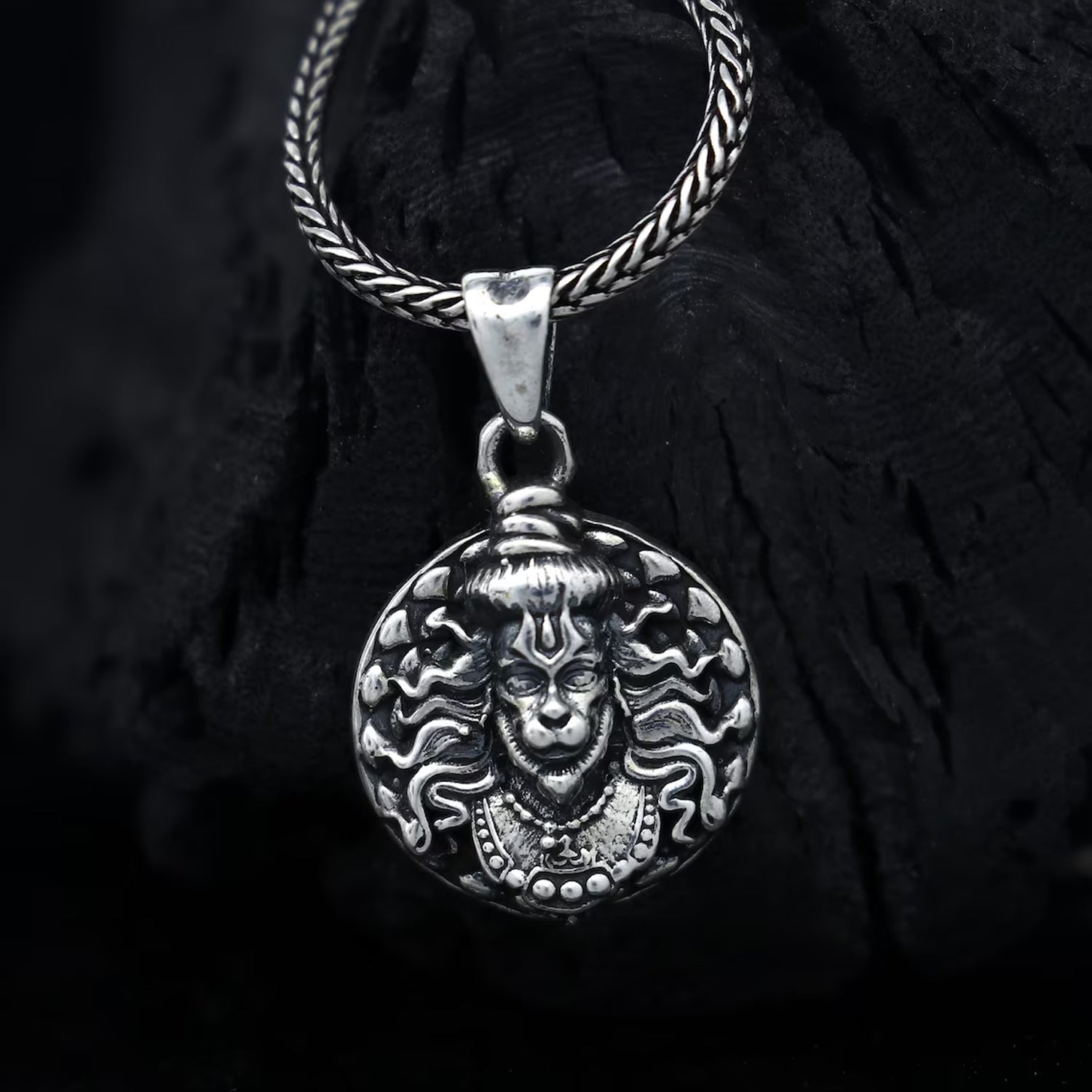 Hanuman facelocket necklace in silver featuring intricate detailing and a braided chain design