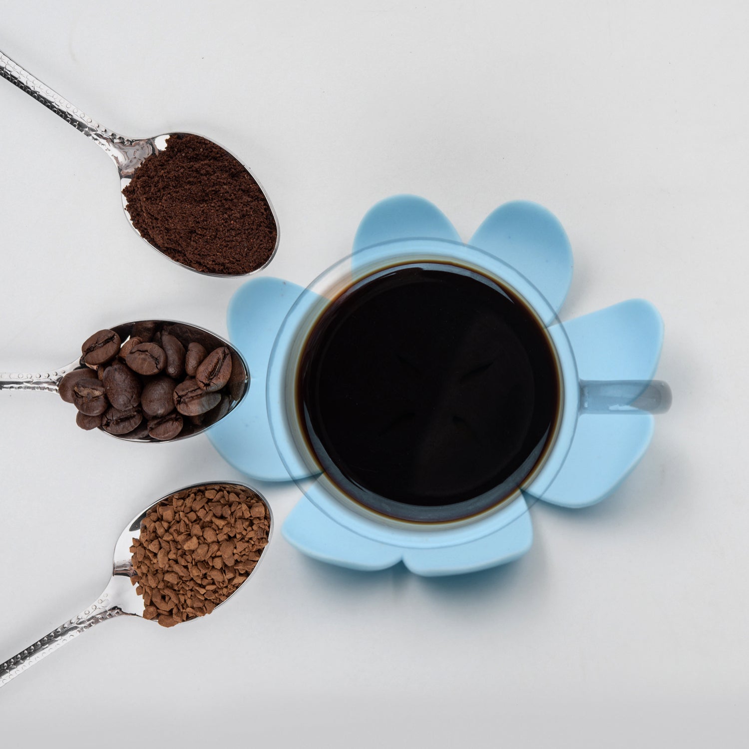 Blue floral heat resistant coasters set with coffee grains and a cup of black coffee