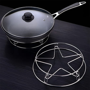 Heavy duty stainless steel gas stove stand with a black frying pan and glass lid on a dark surface