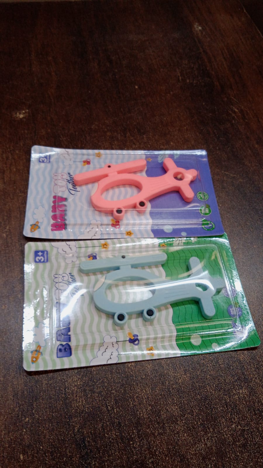 Helicopter shape teether set in pink and blue for soothing baby's gums during teething