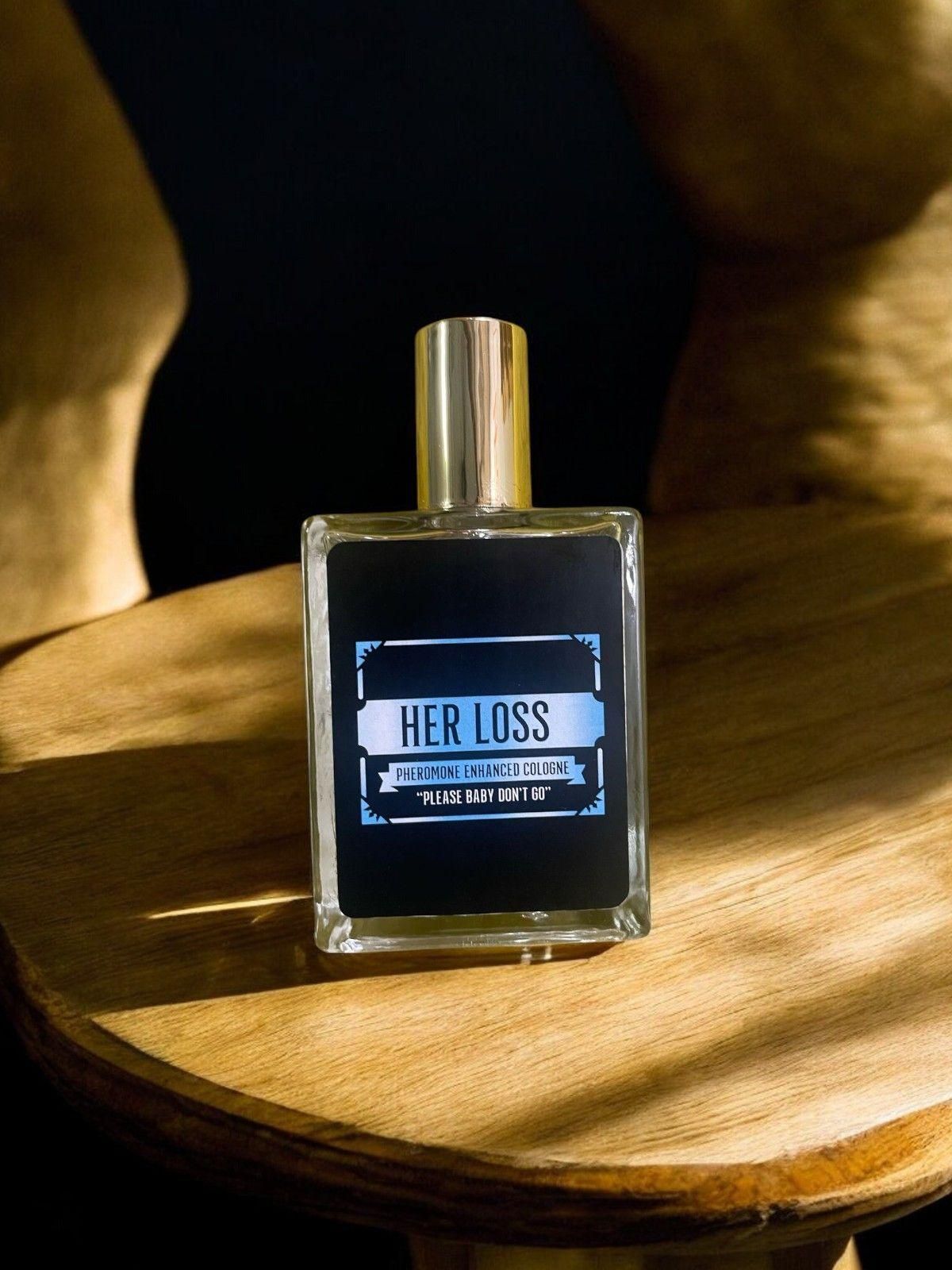 Her Loss signature perfume in a stylish bottle placed on a wooden table with warm lighting