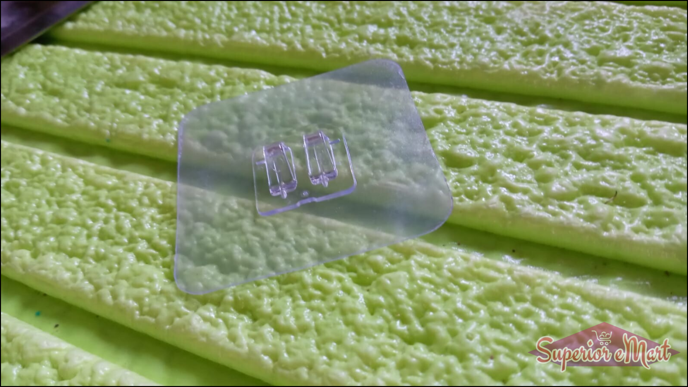 Transparent self adhesive wall hooks on a textured green surface for easy hanging solutions