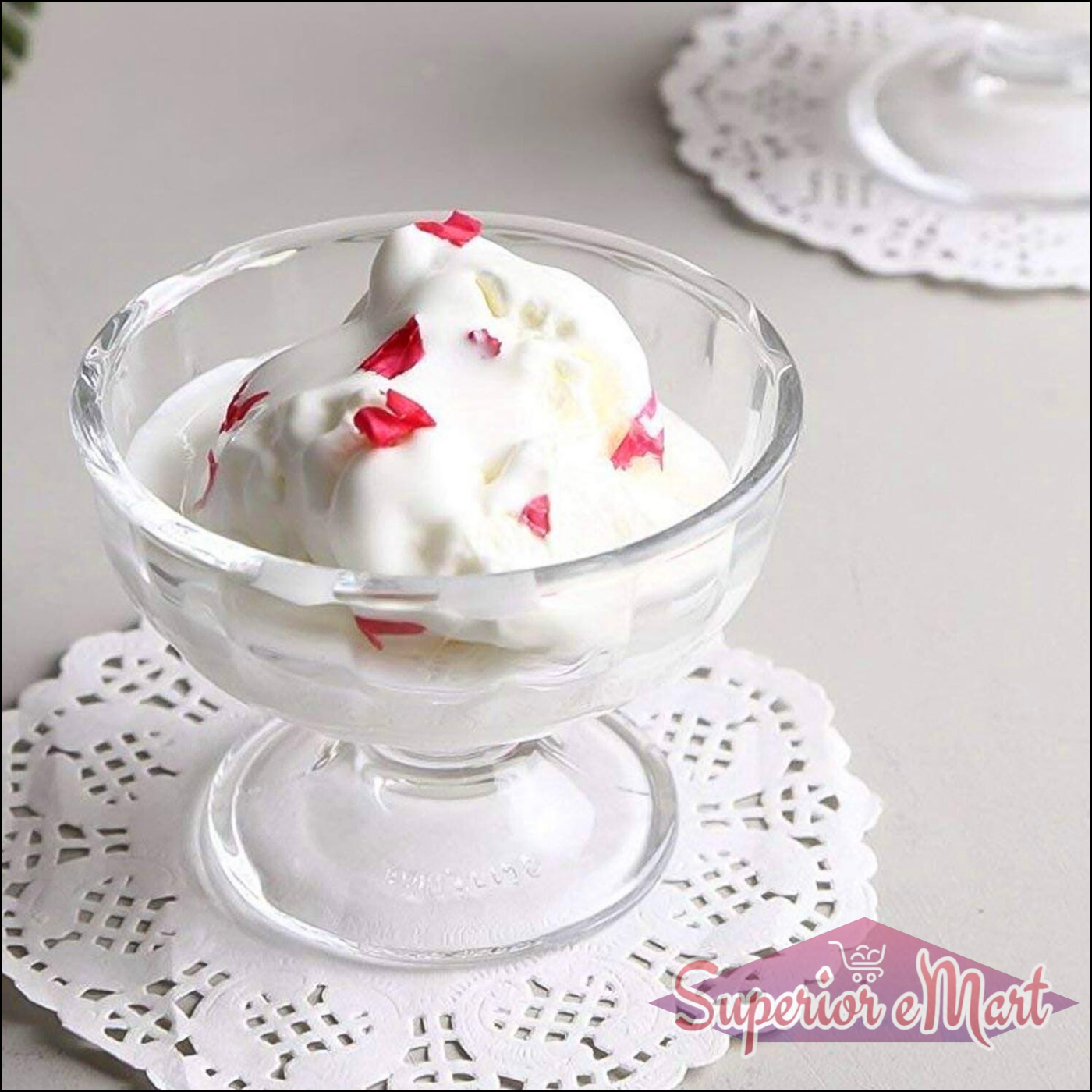 Clear glass ice cream dessert bowl set with whipped cream and colorful toppings
