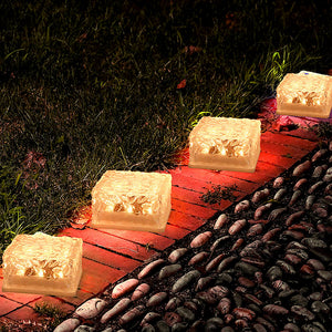 Ice cube shaped outdoor lights illuminating a garden pathway with a warm glow