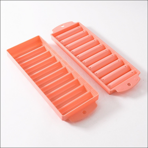 Pink compact ice stick tray with two separate molds for making long ice sticks